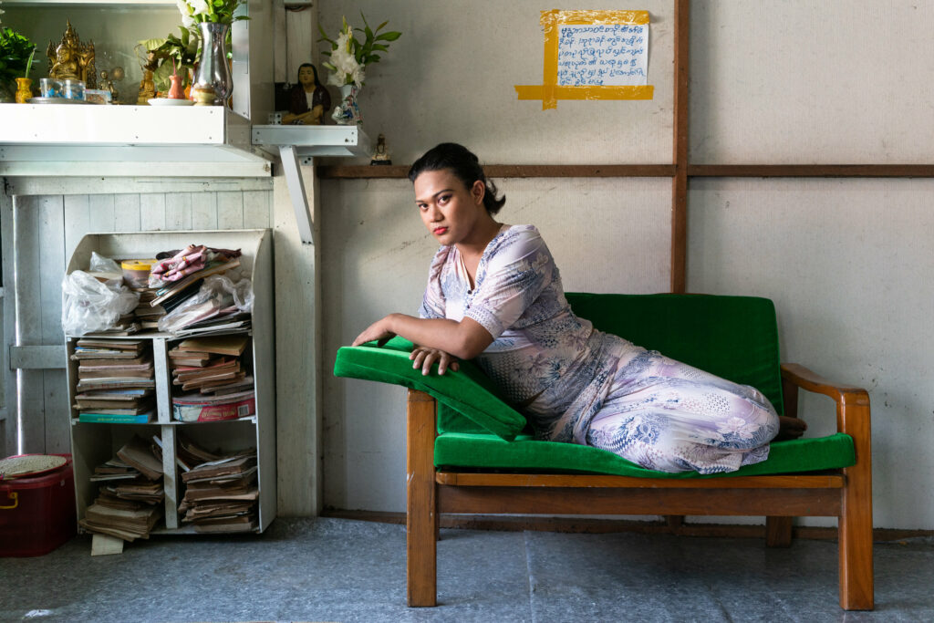 Queen Nicki Rangoon, 24 years-old, poses on a green sofa for a portrait in her bedroom in Yangon, Myanmar.