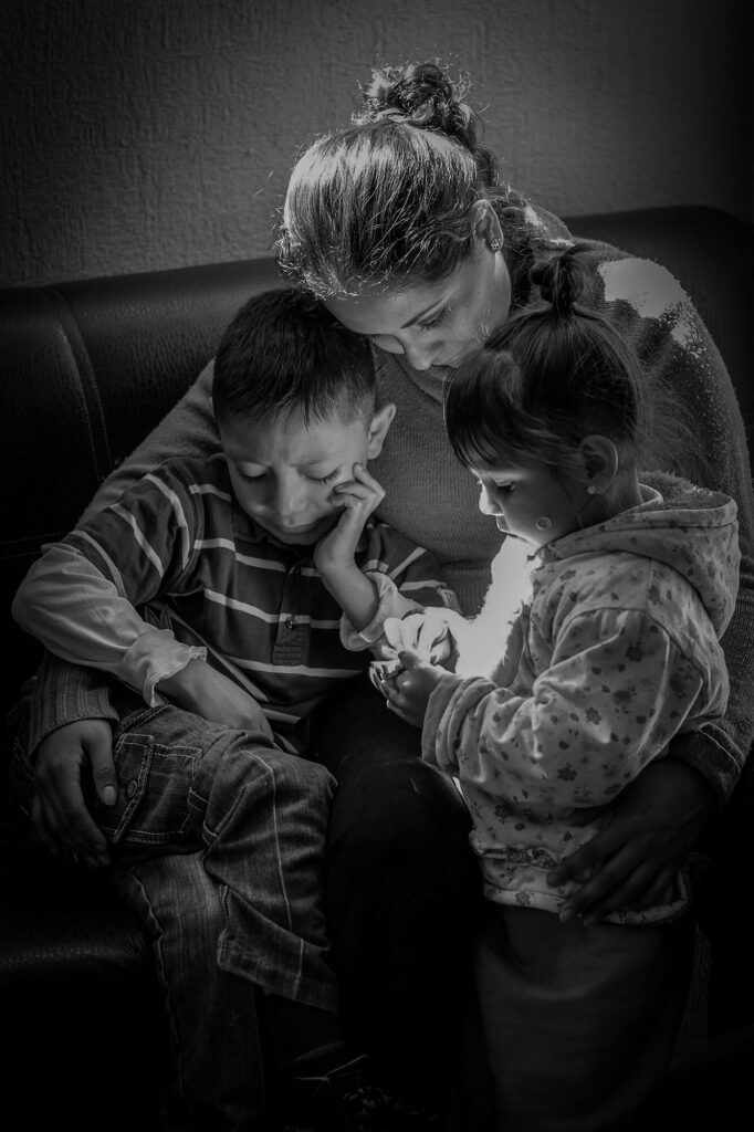 Siomara cradles her niece and nephew at their home in Mexico, where she has cared for them since the femicide of their mother in 2017.