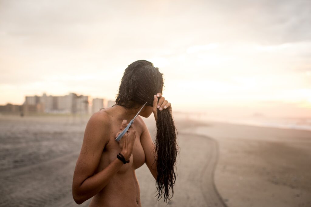 Arisleyda Dilone cuts her hair at Rockaway Beach in New York City.