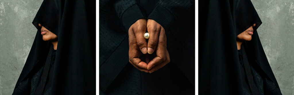 A triptych of a woman in a black cloak holding a pearl within her hands.