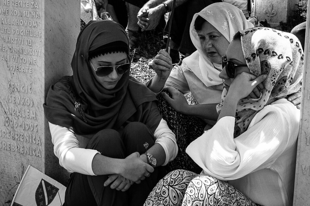 A group of women mourn at the graves of their loved ones who were slaughtered during the massacre.